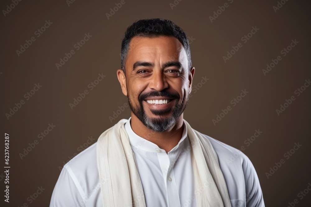 Portrait of a smiling Indian man with a white scarf on his shoulders. Portrait of a smiling Indian man with a white scarf on his shoulders.