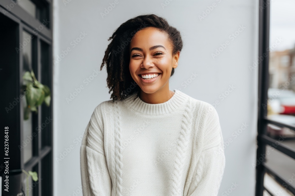 Photo of cheerful african american woman 20s wearing white sweater indoors. Looking aside.