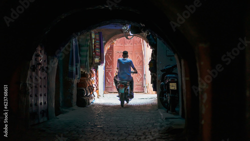 Marrakesh. Motorcycle riding in small alley. 