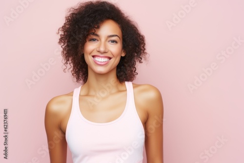 Portrait of a beautiful young african american woman smiling over pink background