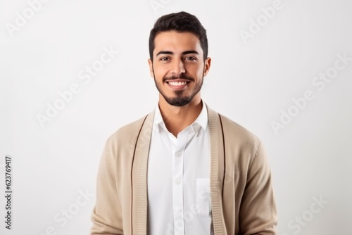 Handsome young man looking at camera and smiling while standing against white background © Robert MEYNER