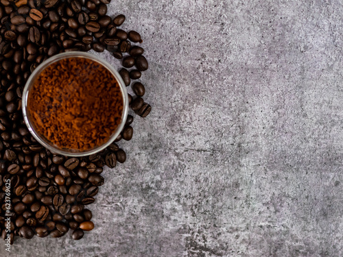 Top shot of roasted coffee beans with defocused powder and copy space.