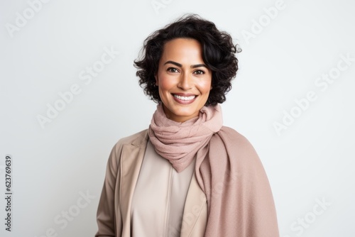 Portrait of smiling woman in beige coat and scarf over white background © Robert MEYNER