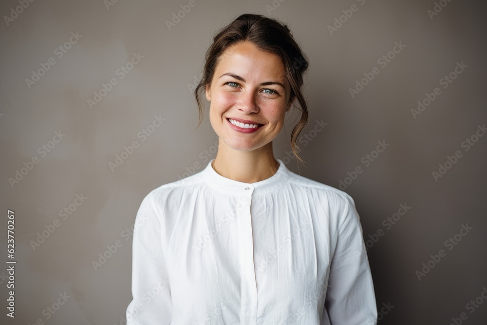 Portrait of a smiling young woman standing against grey wall in room Portrait of a smiling young woman standing against grey wall in room