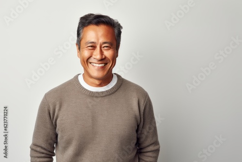 Portrait of smiling asian man looking at camera over white background