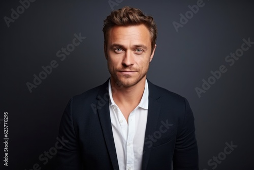 Portrait of a handsome young man in a suit on a dark background