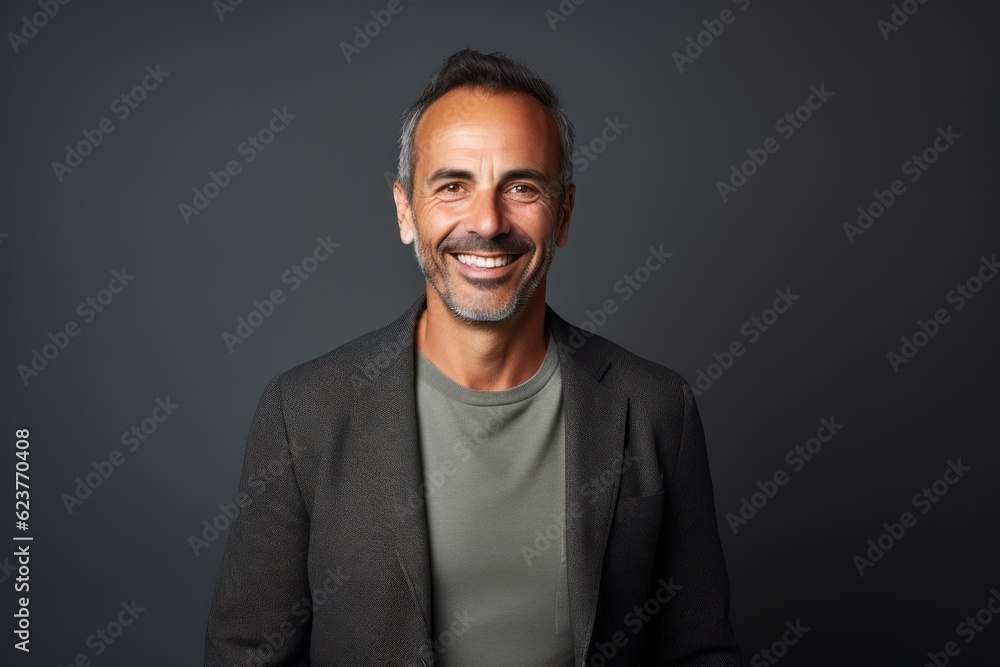 Portrait of handsome mature man smiling at the camera against grey background Portrait of handsome mature man smiling at the camera against grey background
