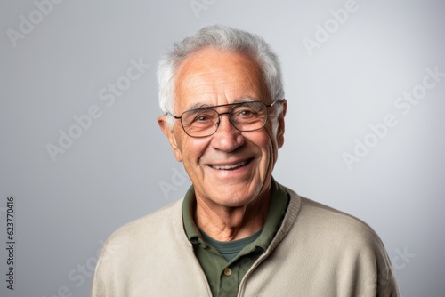 Portrait of a happy senior man with eyeglasses against grey background
