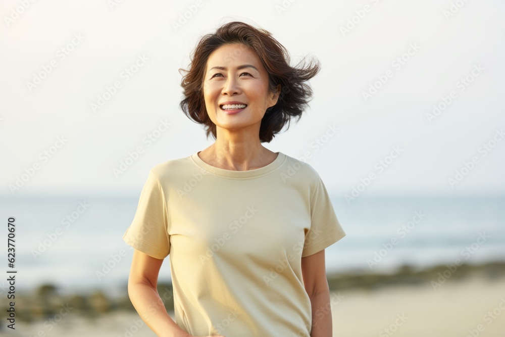 happy asian woman in yellow t-shirt standing on the beach happy asian woman in yellow t-shirt standing on the beach