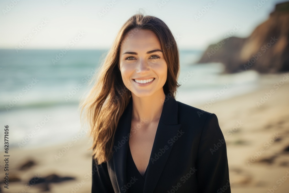 Portrait of beautiful young woman smiling at camera while standing on beach