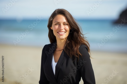 Portrait of a young businesswoman smiling at camera on the beach