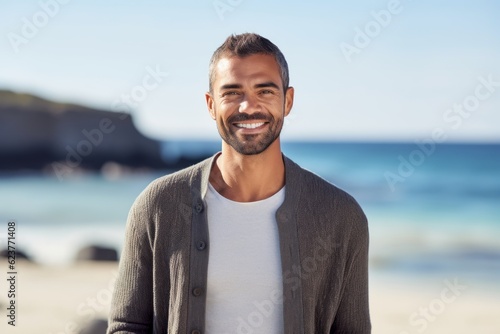 Portrait of a smiling young man standing on the beach at the day time