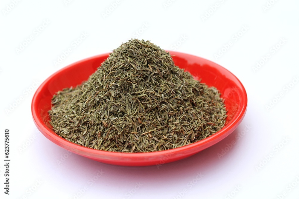 Dried thyme leaves in a plate on white background Dried thyme leaves in a plate on white background