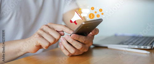 close up adult man hand hold smartphone to use affiliated marketing on web with virtual icon to announce campaign and promotion to social media network for referral partner program concept