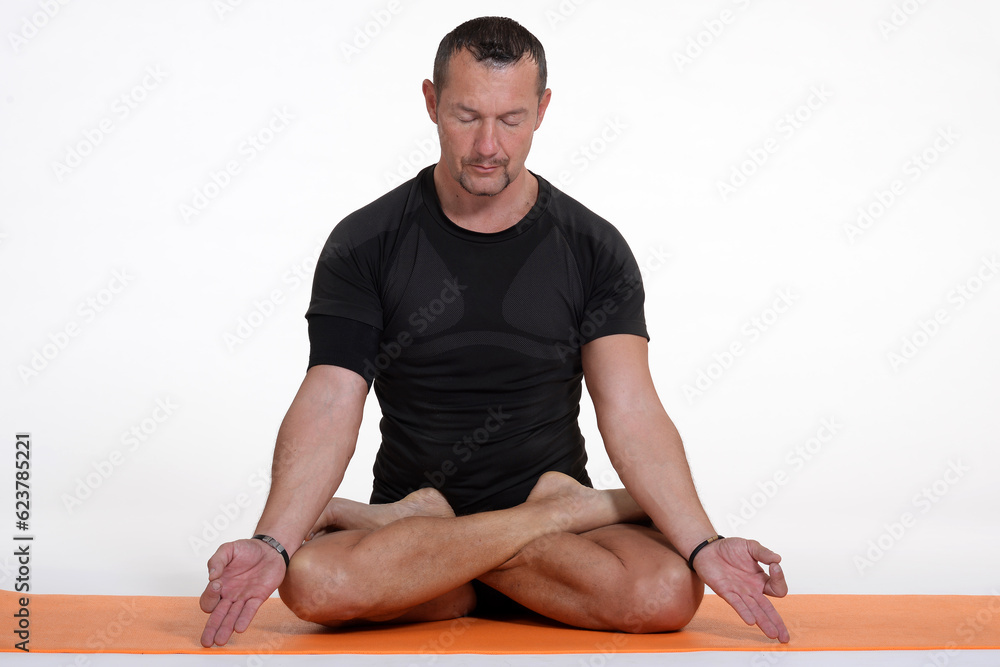Fototapeta premium Man doing yoga in photo studio on isolated background. 