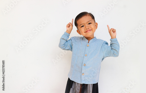 Excited little boy raising his hand and pointing up