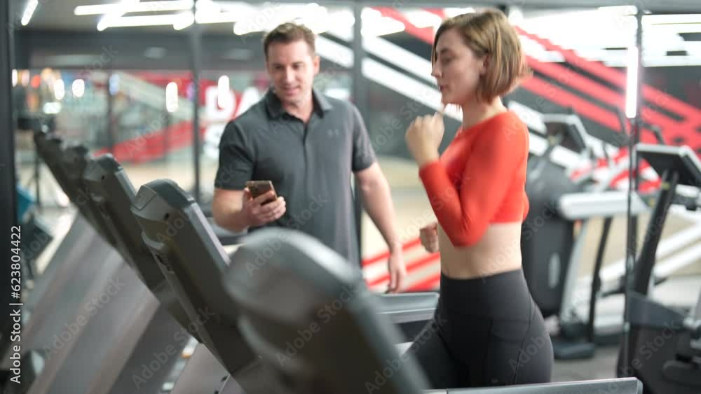 Young Caucasian woman running on a treadmill in health club. Young Caucasian woman running on a treadmill in health club.
