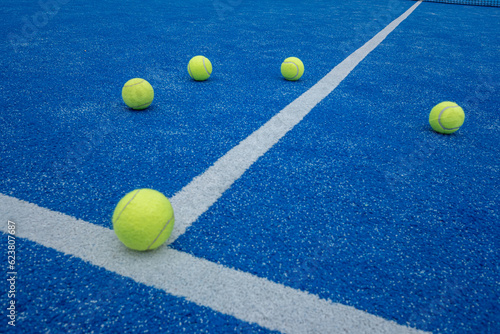 selective focus, five balls on a blue paddle tennis court . Racket sports concept