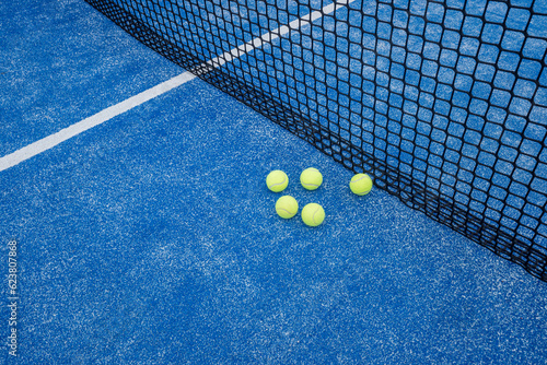 blue paddle tennis court with five balls near the net © Vic