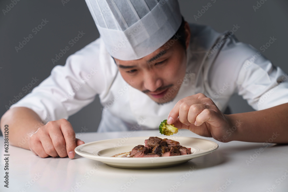 Middle-aged man in chef's uniform prepares delicious food Middle-aged man in chef's uniform prepares delicious food