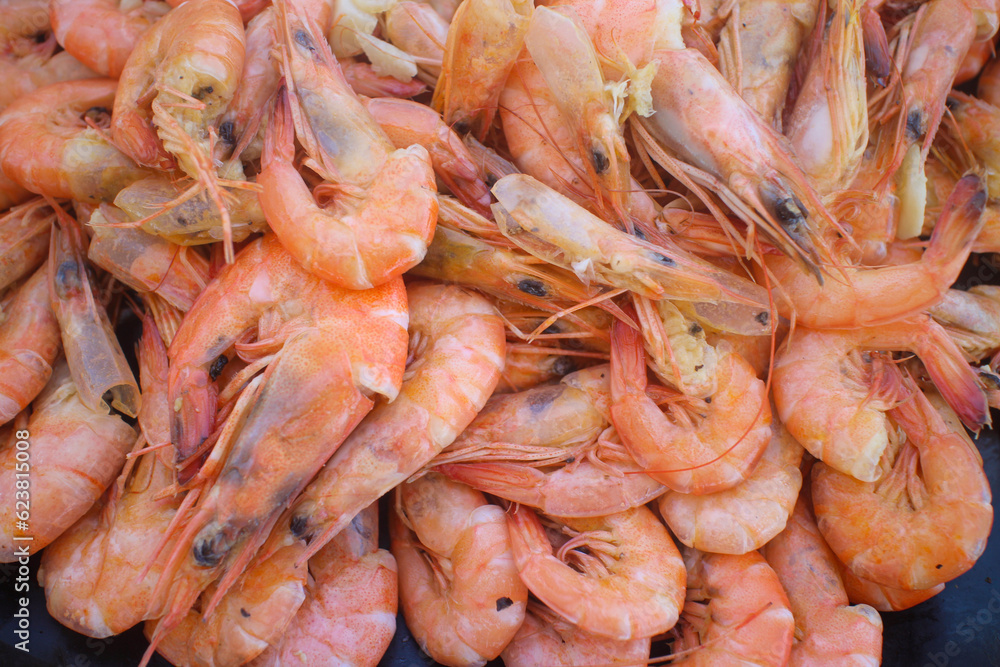 A Close-up shot of a platter of cooked fresh shrimp with garlic bits that is part of the seafood boodle fight in the Philippines A Close-up shot of a platter of cooked fresh shrimp with garlic bits that is part of the seafood boodle fight in the Philippines
