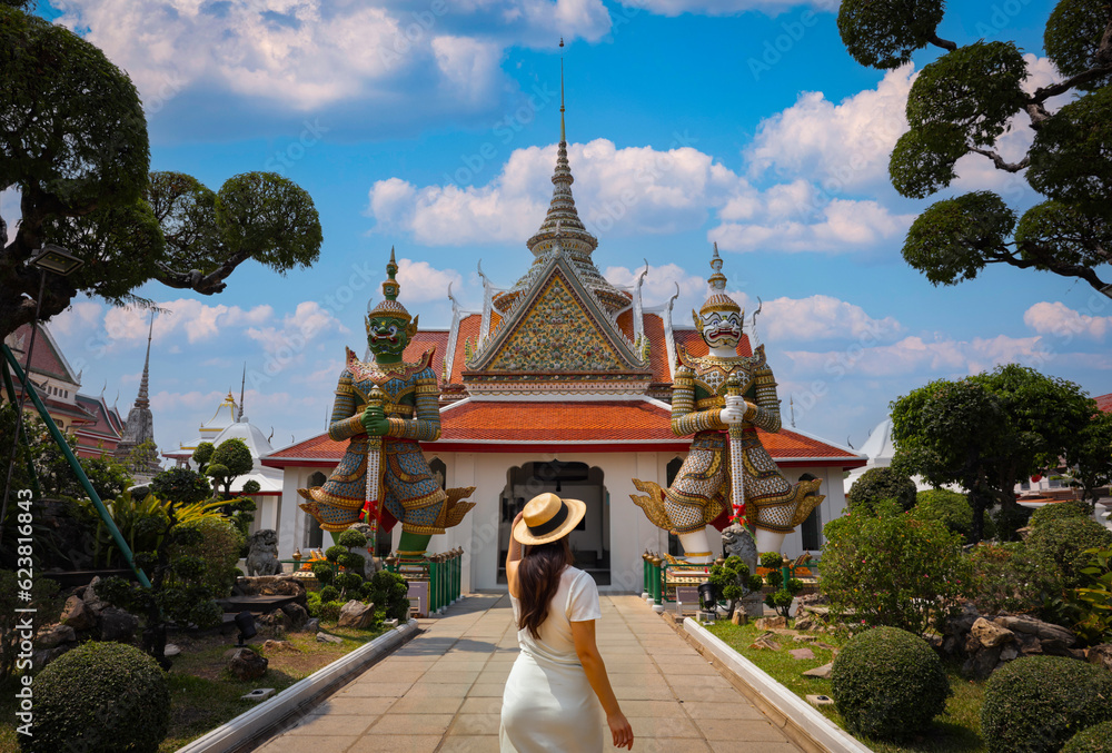 The tourist woman standing over the main entrance of the Temple of Wat Arun 