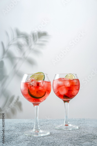 Campari and Tonic. Classic alcoholic cocktail drink with red bitter. Alcohol drink with lime. Campari and Tonic cocktail with lime.