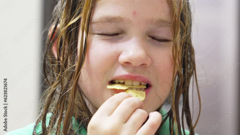 Cute teenage girl with wet hair eating potato chips. Cute teenage girl with wet hair eating potato chips.