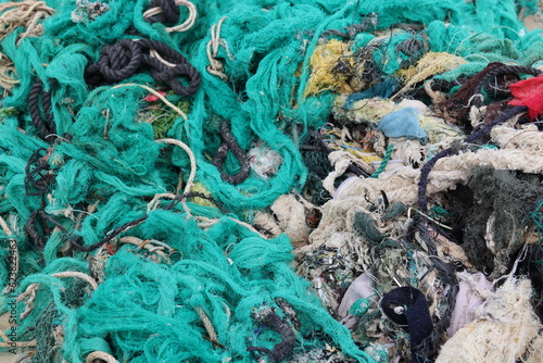 Tuy Hòa, Vietnam. 21-02-2023. Twisted fishingnets, ropes, plastic, clothes and other garbage tangled into each other on a beach. photo