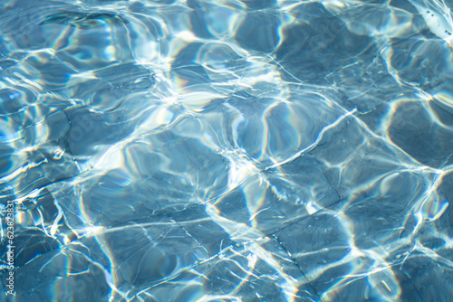 Cleary blue water surface which is reflected with sunlight. Abstract texture photo, close-up.