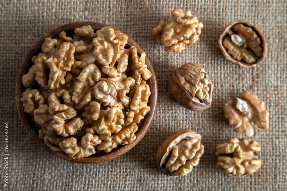 Peeled walnuts and whole walnuts on burlap sack Peeled walnuts and whole walnuts on burlap sack