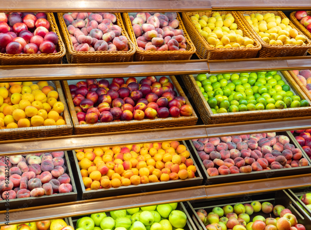 Assortment of fresh fruits on store shelves, on market counter.