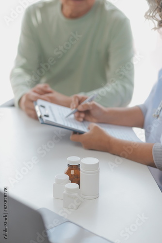 A health visitor with tablet explaining a senior woman how to take pills.