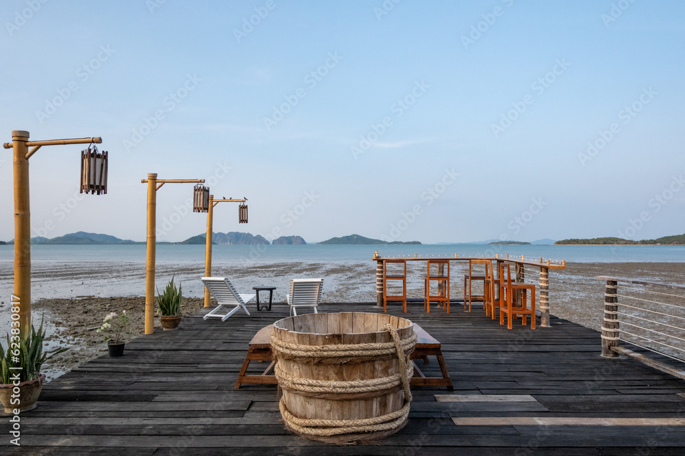 Obraz premium Outdoor seating and bar counter on the terrace, with view of the sea on the background