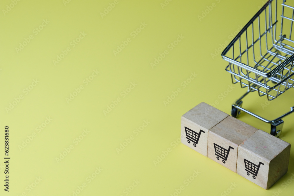 Online shopping,Home delivery,ecommmerce,Online store concept.,Top Shopping cart with shopping cart on wooden cubes over yellow background perfect for technology,business idea. Online shopping,Home delivery,ecommmerce,Online store concept.,Top Shopping cart with shopping cart on wooden cubes over yellow background perfect for technology,business idea.