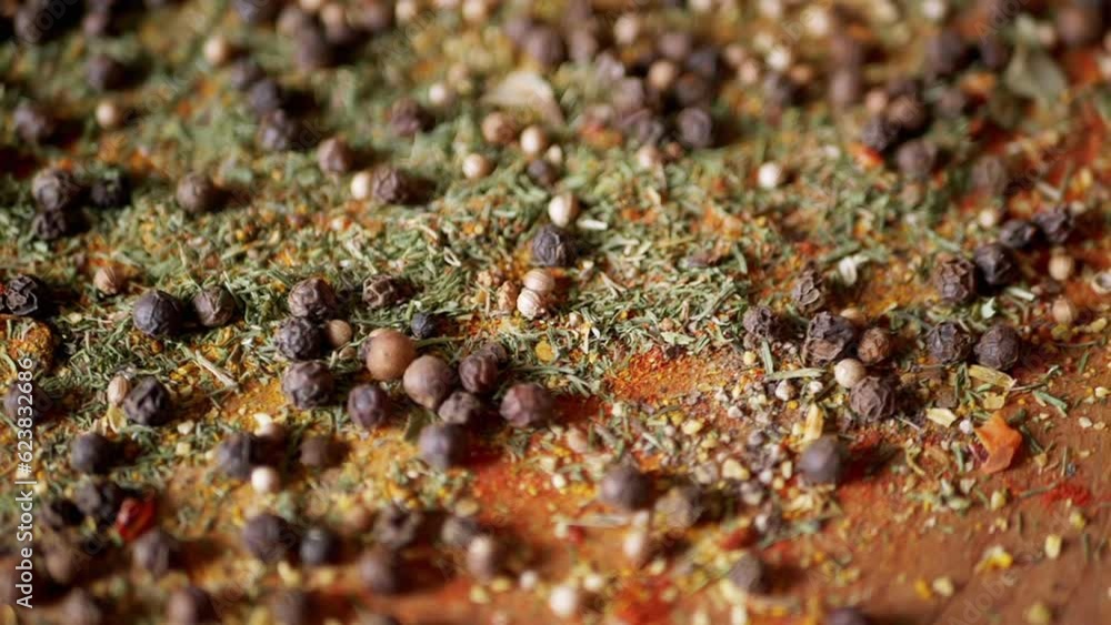 Scattered Various Multicolored Indian Dry Spices on a Rotating Wooden Background. Allspice, black peppercorns, dried herbs, dill, paprika, turmeric, oregano. Fragrant set of seasonings for cooking. Scattered Various Multicolored Indian Dry Spices on a Rotating Wooden Background. Allspice, black peppercorns, dried herbs, dill, paprika, turmeric, oregano. Fragrant set of seasonings for cooking.
