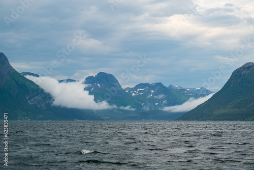 A troubled sea and clouds in the mountains.