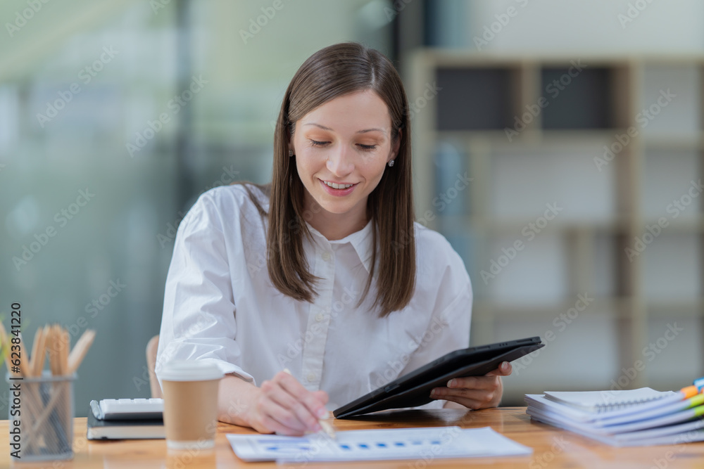 Portrait of beautiful smiling young brunette businesswoman sitting at in the office modern work station Portrait of beautiful smiling young brunette businesswoman sitting at in the office modern work station
