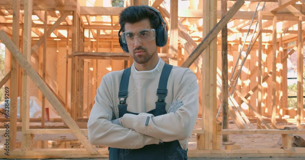 confident caucasian man carpentry worker in uniform standing with crossed arms in front of wooden construction Slow motion Profession builder has rest Lifestyle Leisure confident caucasian man carpentry worker in uniform standing with crossed arms in front of wooden construction Slow motion Profession builder has rest Lifestyle Leisure