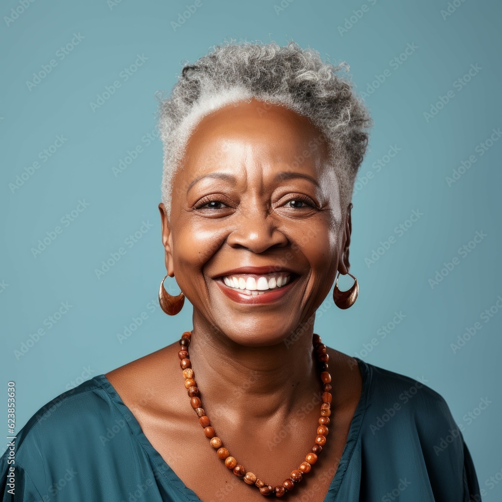 Portrait of a smiling senior African woman with short gray hair on a blue background. Happy old African American woman with a smile in a blue shirt looking at camera. Aged woman with shiny white teeth Portrait of a smiling senior African woman with short gray hair on a blue background. Happy old African American woman with a smile in a blue shirt looking at camera. Aged woman with shiny white teeth