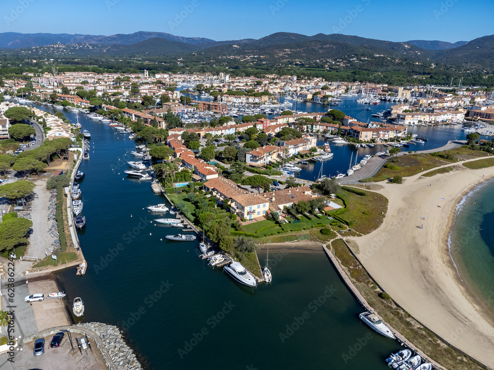 Arial view on blue water of Gulf of Saint-Tropez, boats, houses in Port Grimaud and Port Cogolin, villages on Mediterranean sea with yacht harbour, Provence, summer vacation in France