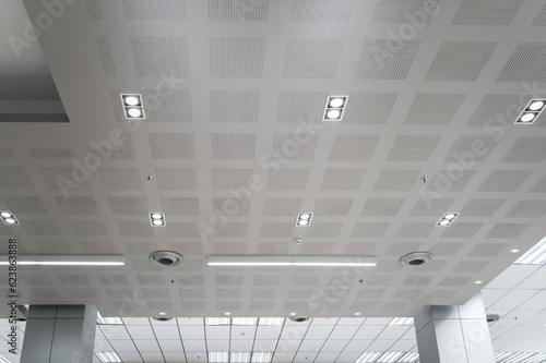 Ceiling mounted cassette type air conditioner and modern lamp light on white ceiling. Duct air conditioner for home, hall or office.