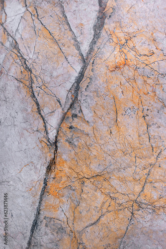 The texture of a marble slab with a pink-brown tint with cracks and veins.