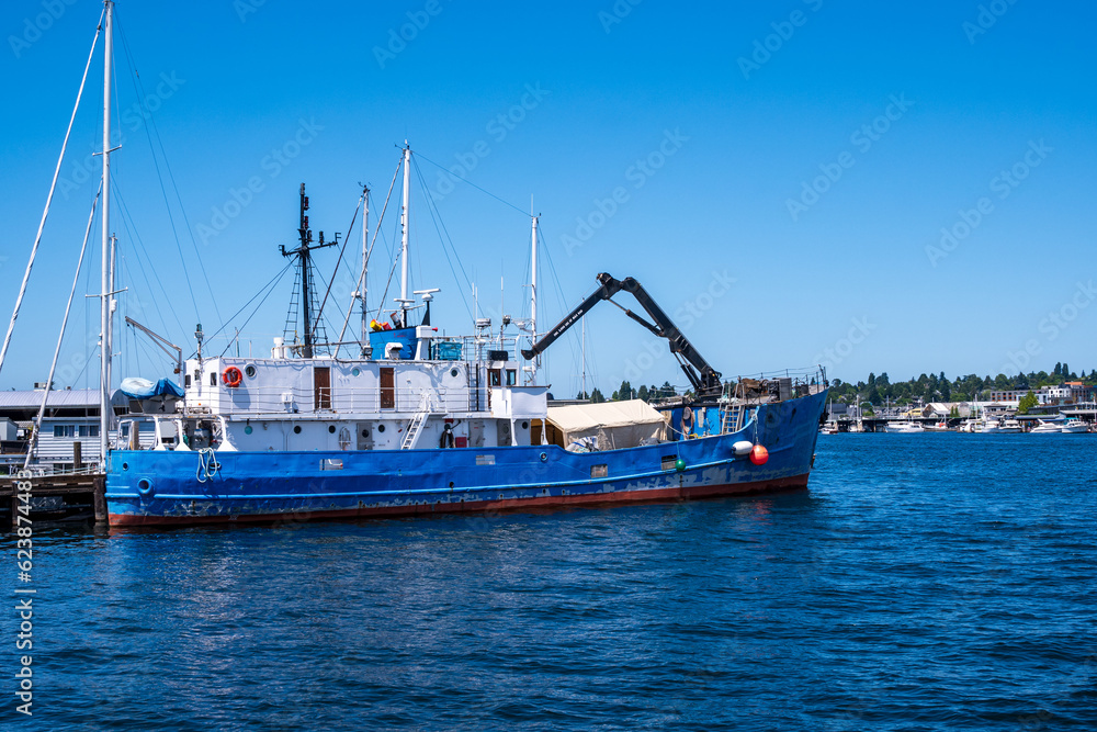Industrial salmon fishery: a salmon fleet tender or support vessel sits idle at dock in ballard seatle washington in summer.