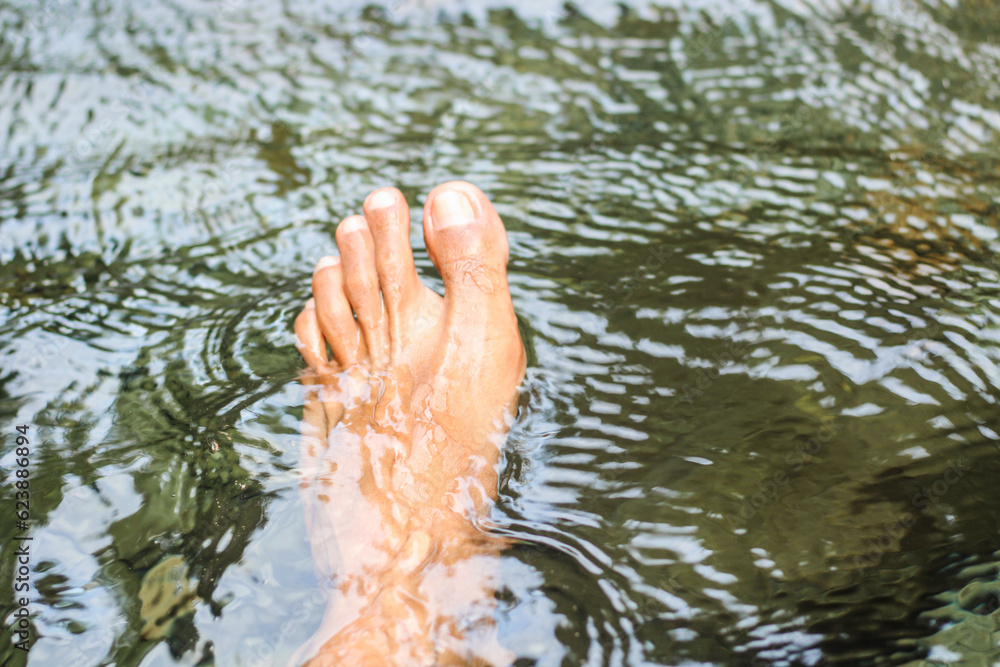 Man's left foot in the water Man's left foot in the water