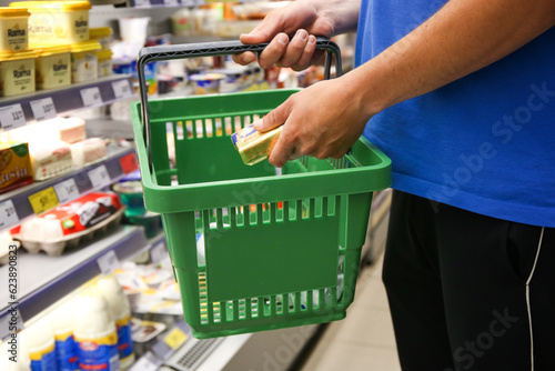 a man puts butter into a grocery cart in a store, close up