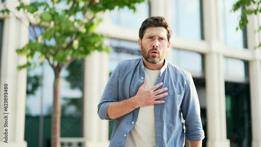 Overworked mature man employee suffers from strong sudden pain in the heart symptom heart attack while sitting on bench near business office centre Stressed male holding chest having ache Overworked mature man employee suffers from strong sudden pain in the heart symptom heart attack while sitting on bench near business office centre Stressed male holding chest having ache
