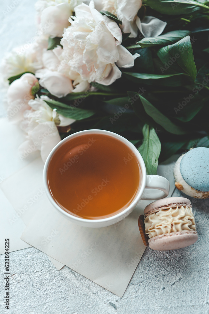 Cup of tea, macaroons and peonies, flat lay top view. good morning concept Cup of tea, macaroons and peonies, flat lay top view. good morning concept
