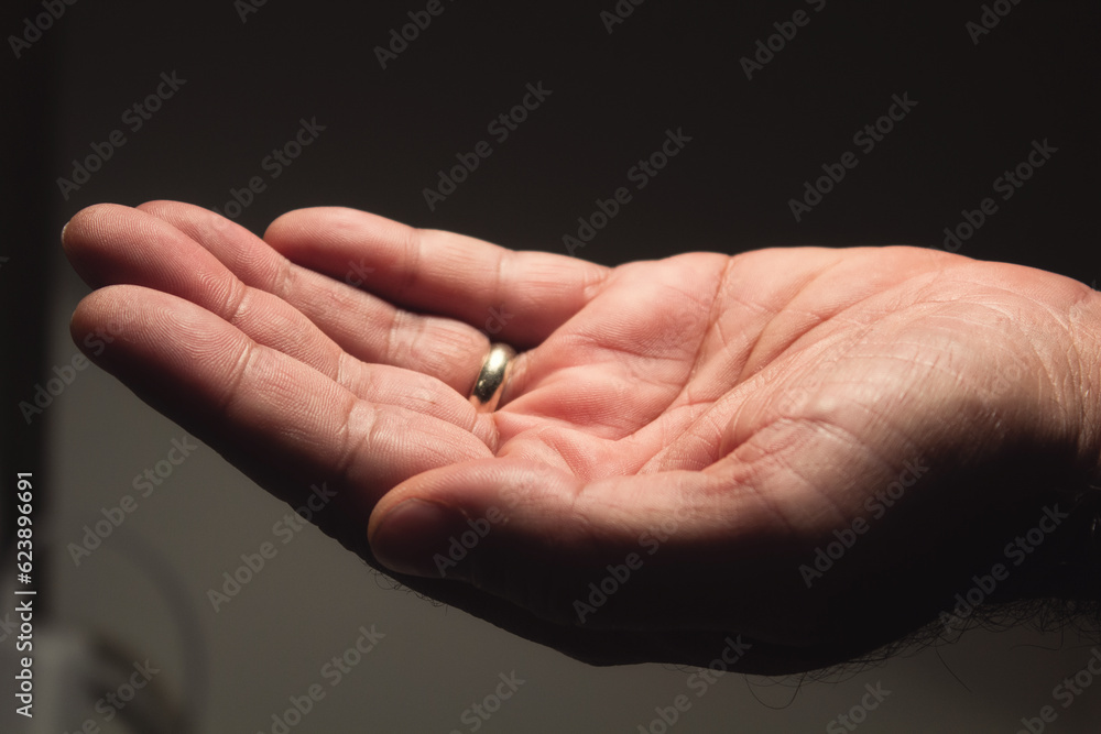 Male hand with marriage ring open upwards Male hand with marriage ring open upwards