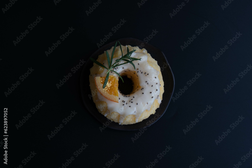 Top view Orange bundt cake topped tangerines and rosemary on a white plate Top view Orange bundt cake topped tangerines and rosemary on a white plate